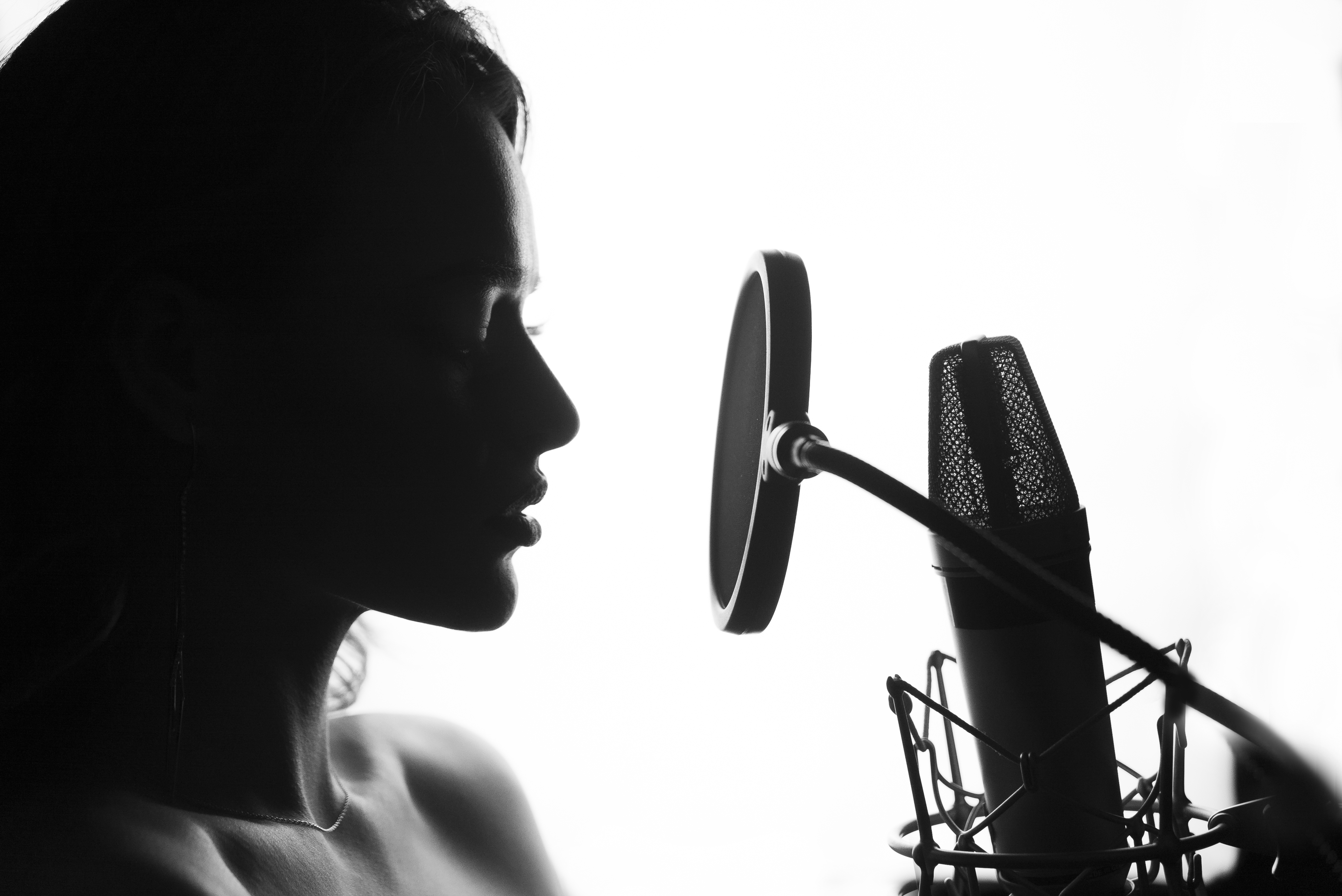 Black and White. Woman singing in the recording studio. Profile of a woman with a beautiful face and lips.